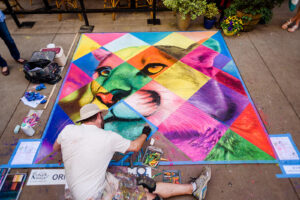 Dogwood arts festivale chalk art contest artwork of lion with colorful diamond pattern over the top